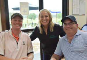 college president with golfers inside the clubhouse