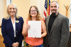 three people, with one holding a signed contract